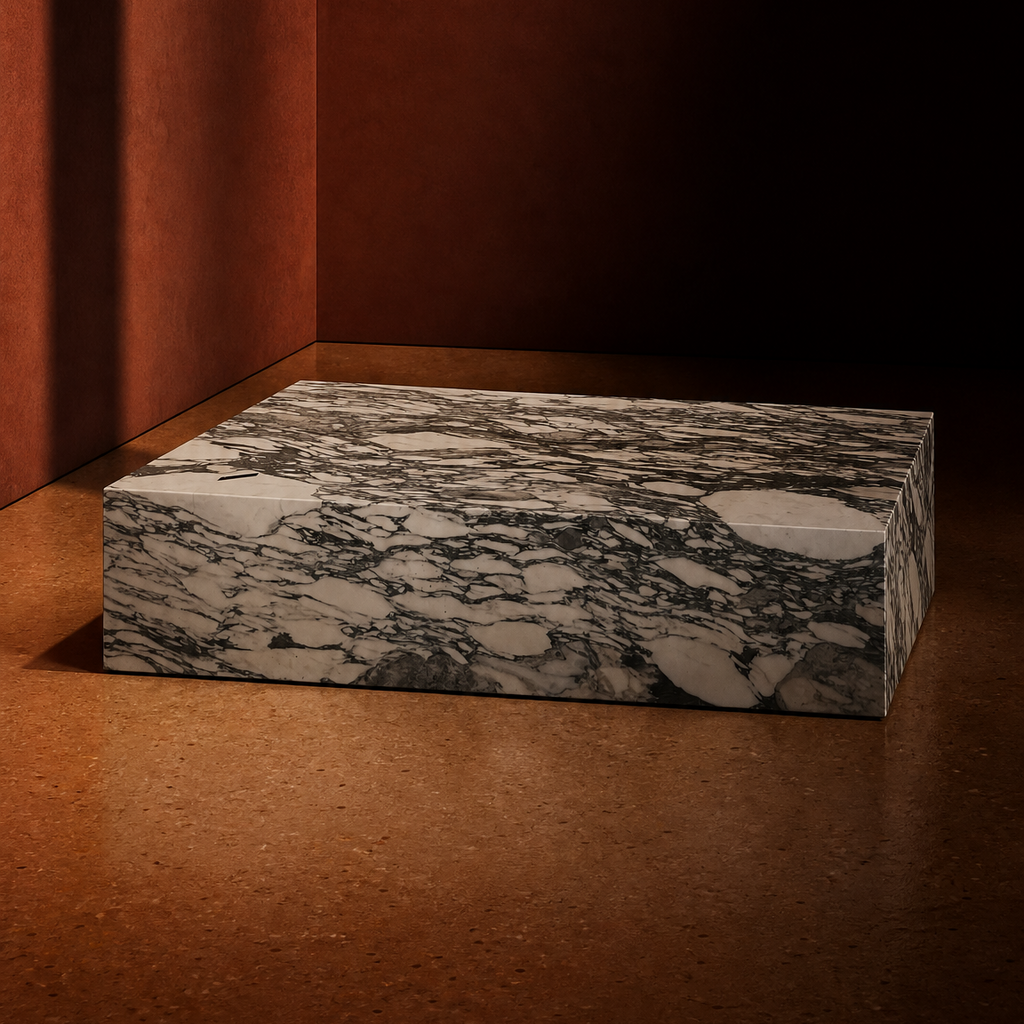 A rectangular marble coffee table with a gree-gray and white veined pattern, set on a warm brown surface against a dark brown textured background.