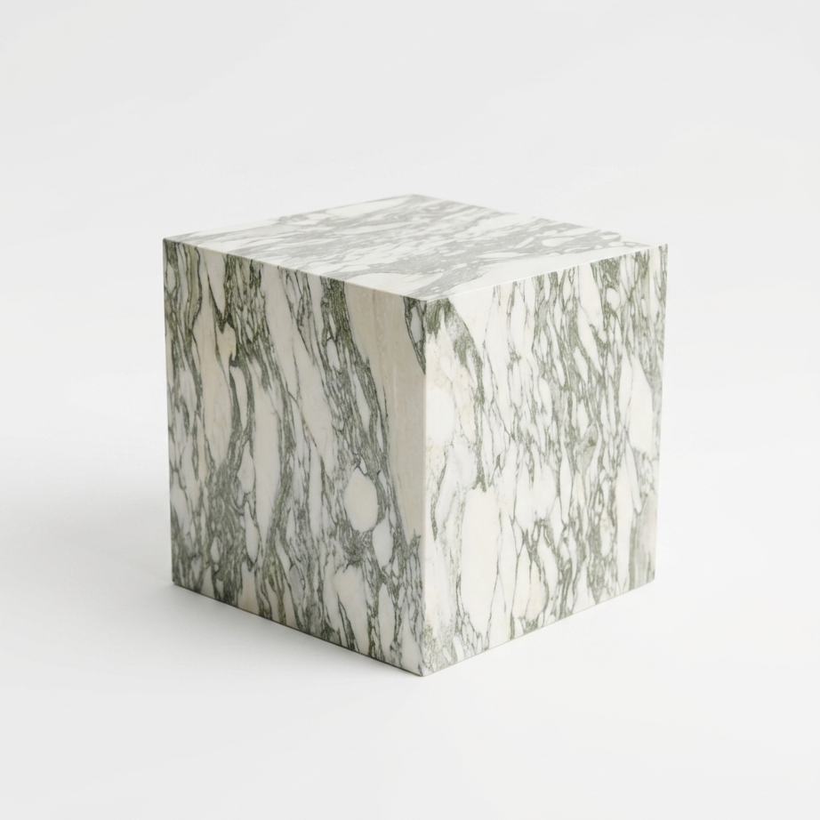 A cube-shaped side table or stool with a white marble pattern featuring gray and green veining, set against a plain white background.