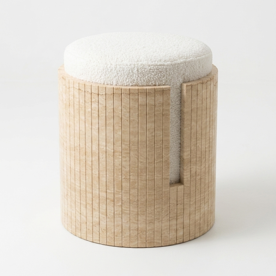 A modern cylindrical ottoman stool with a light travertine fluted base and a round off-white textured fabric cushion, shown on a clean white background.