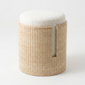 A modern cylindrical ottoman stool with a light travertine fluted base and a round off-white textured fabric cushion, shown on a clean white background.