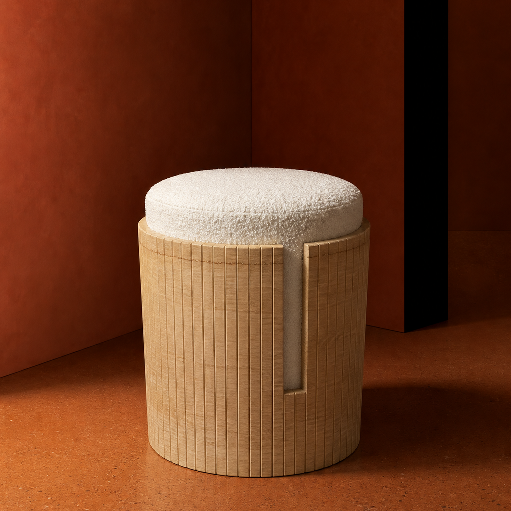 A modern cylindrical stool with a textured beige travertine frame and a round off-white boucle cushion, set against a warm terracotta-colored background.
