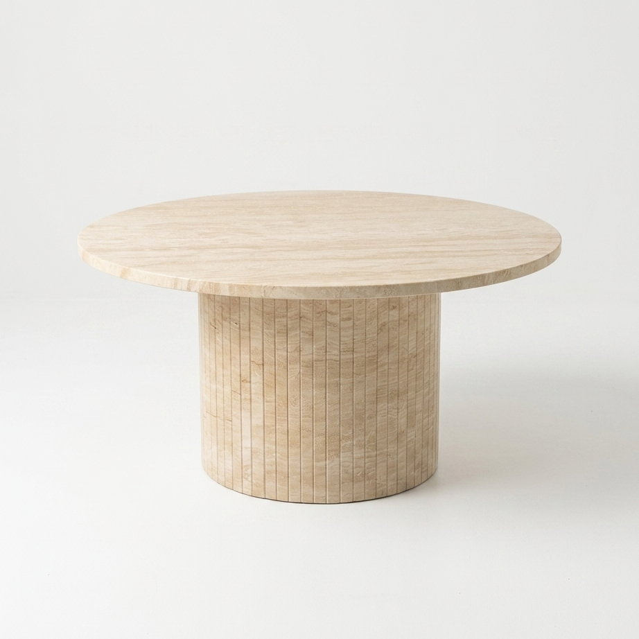 A round coffee table with a light beige travertine top and a cylindrical pedestal base made of travertine, shown on a seamless white background.
